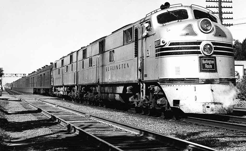 A close up black and white photo of a train sitting on the tracks