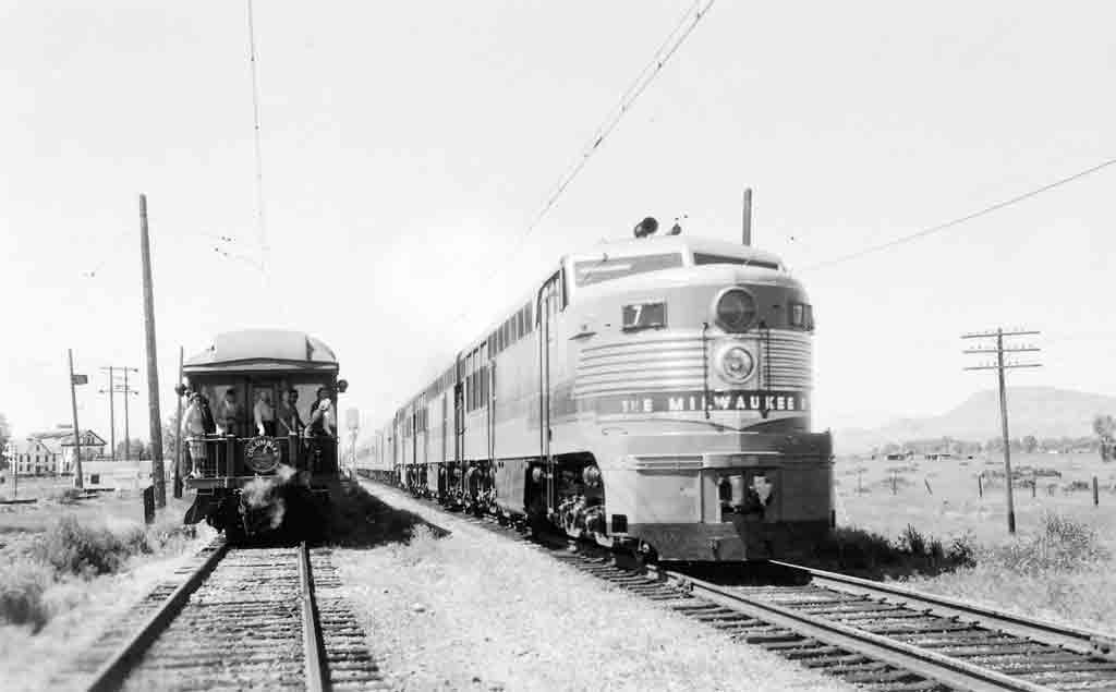 A black and white photo of two trains traveling side by side
