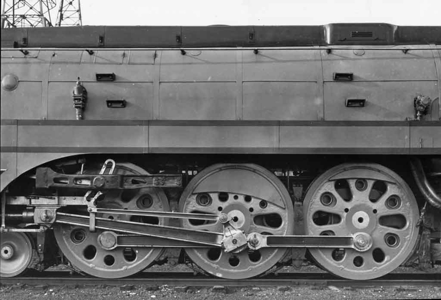 A black and white close up photo of the wheels of a train