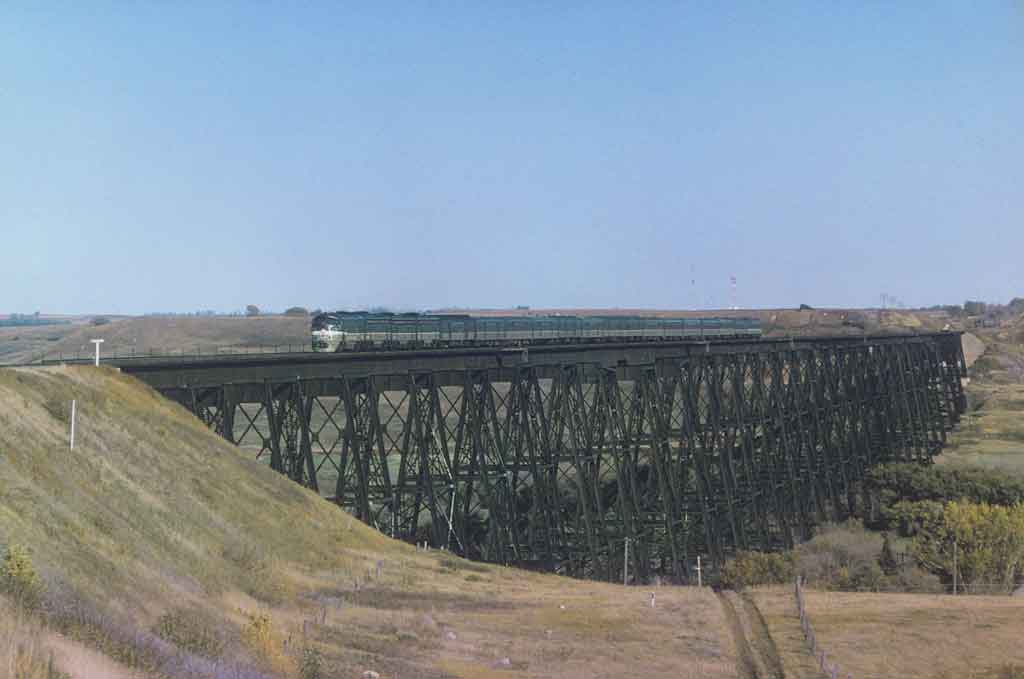 A distant shot of a locomotive crossing a bridge