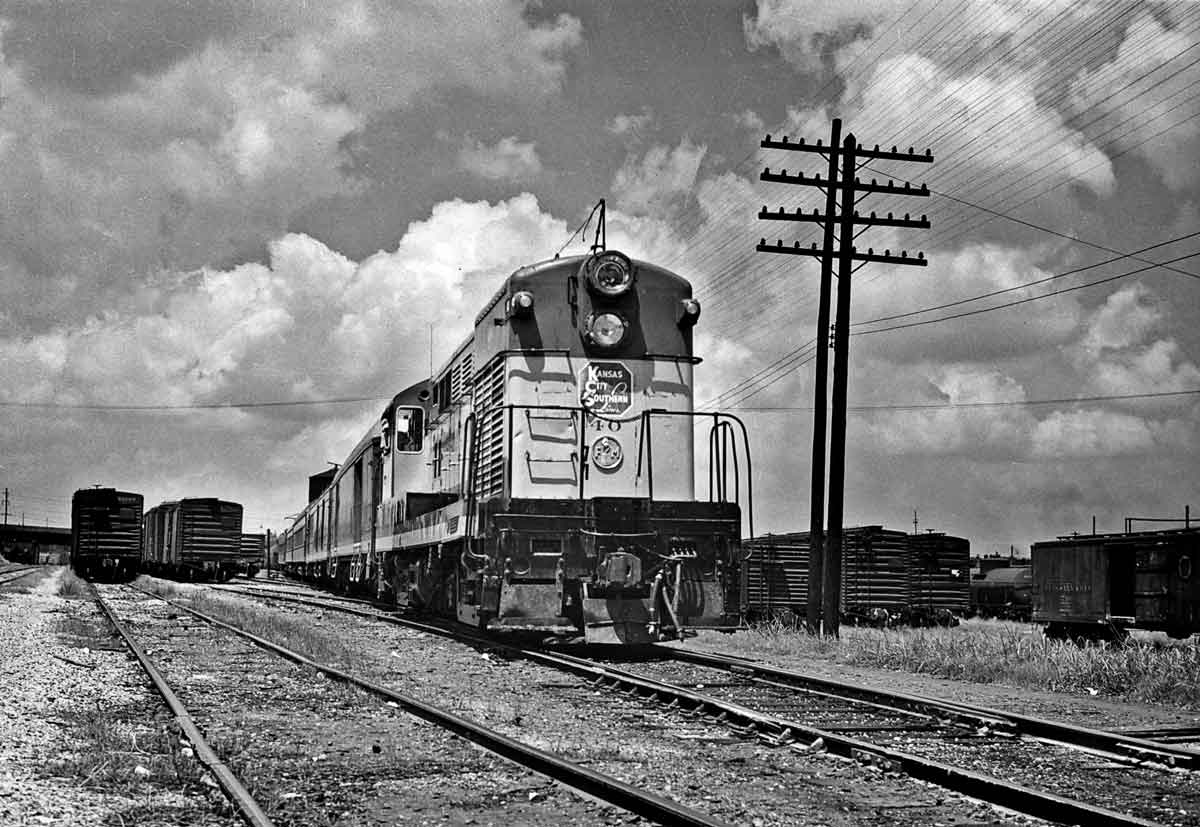 Diesel locomotive with passenger train in freight yard