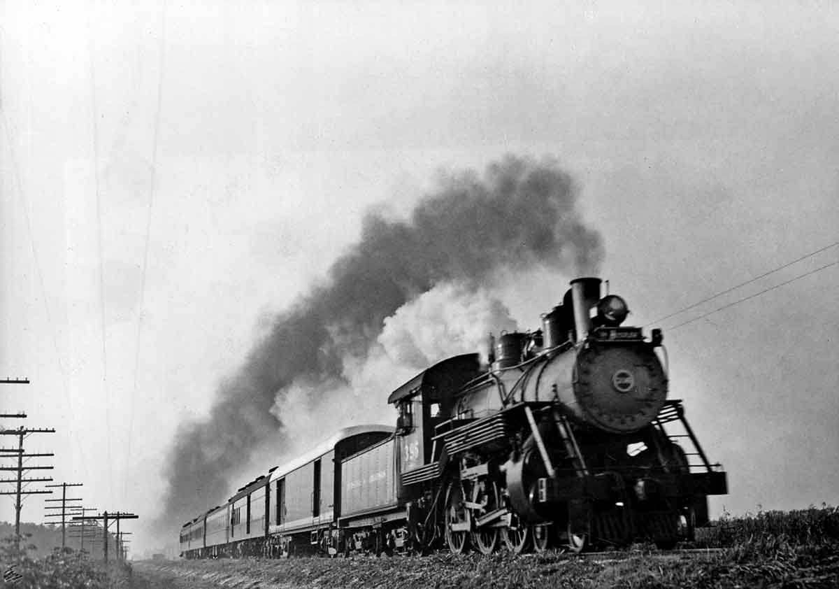 Steam locomotive with five car passenger train at speed