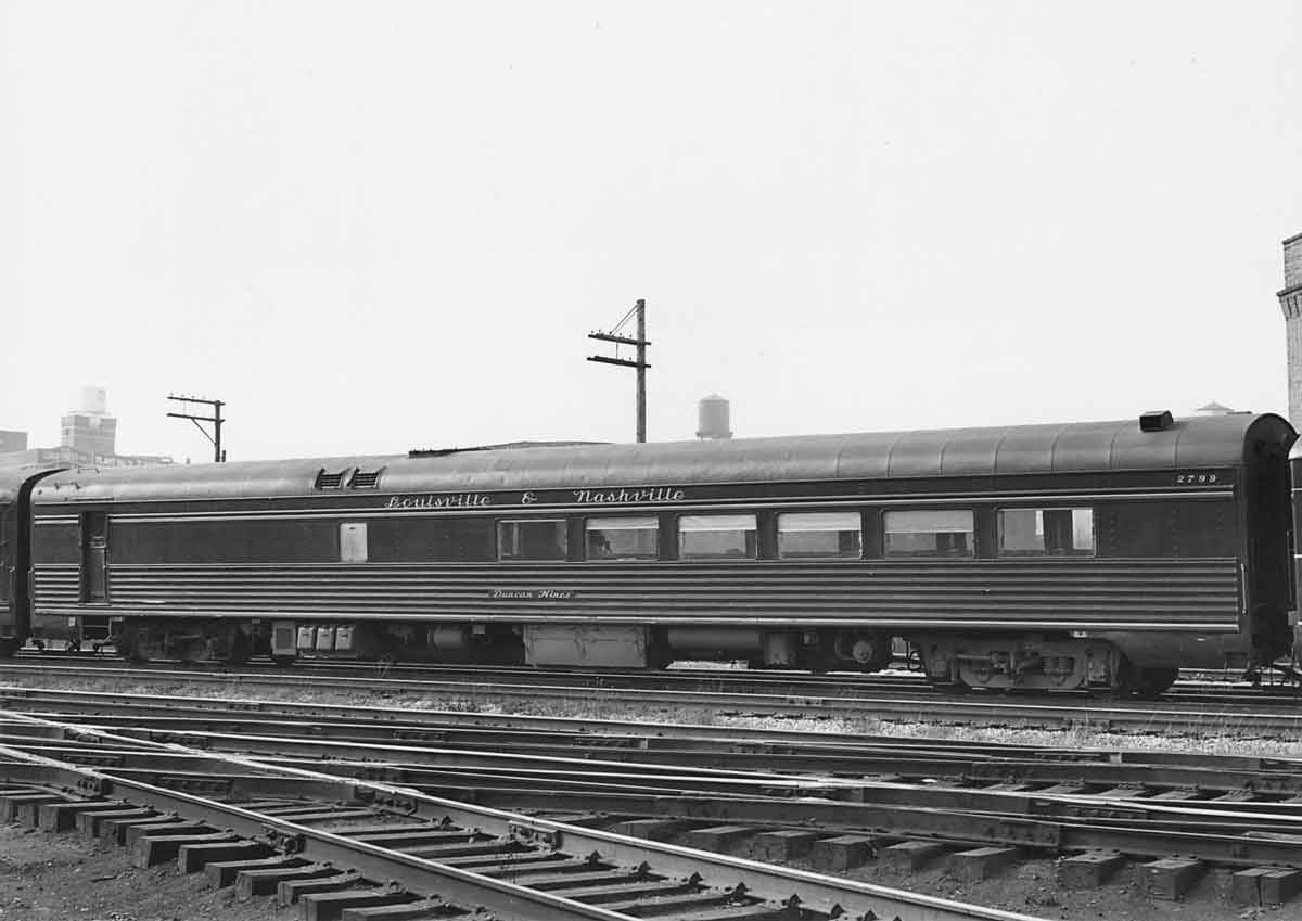 A black and white photo of a train parked on the tracks