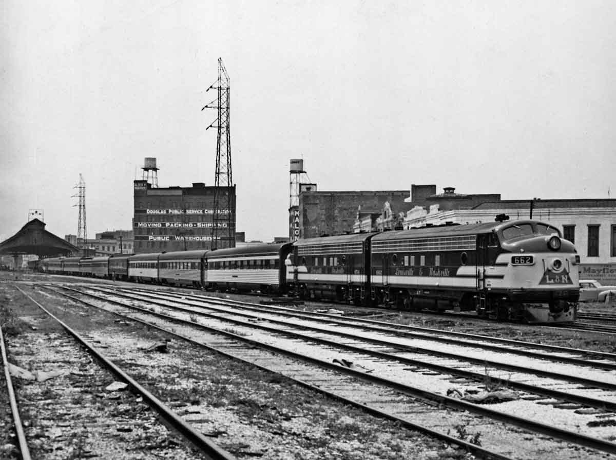 A black and white photo of a train parked at a station
