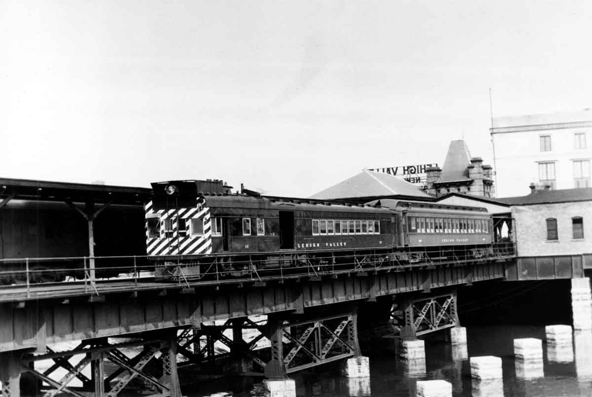 A black and white photo of a locomotive crossing a bridge
