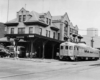 A black and white photo of a train outside a train station
