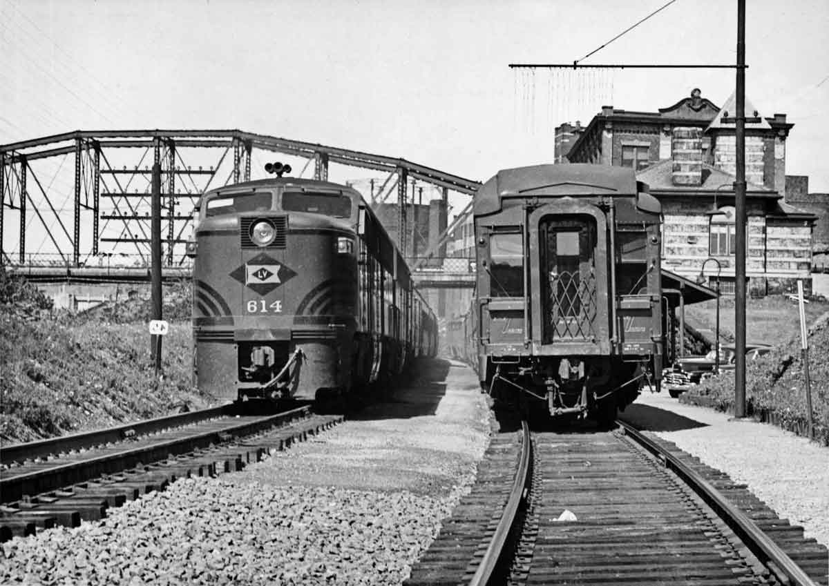 A black and white photo of two trains passing eachother on the tracks