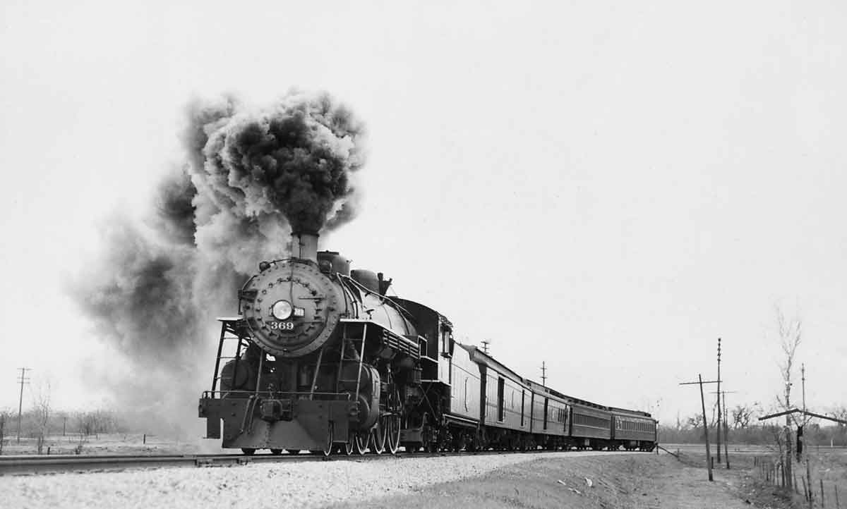 a steam engine pulling passenger cars