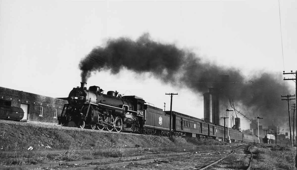 a steam engine pulling passenger cars