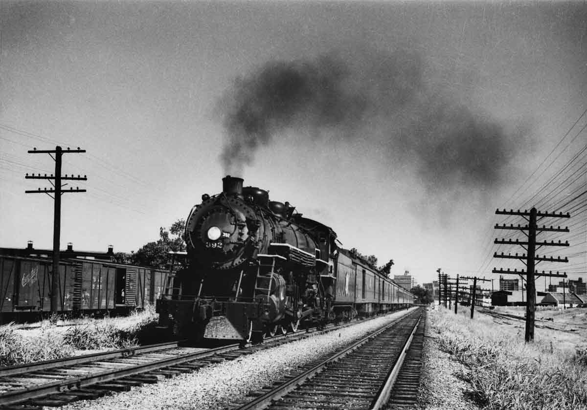 a steam engine pulling passenger cars