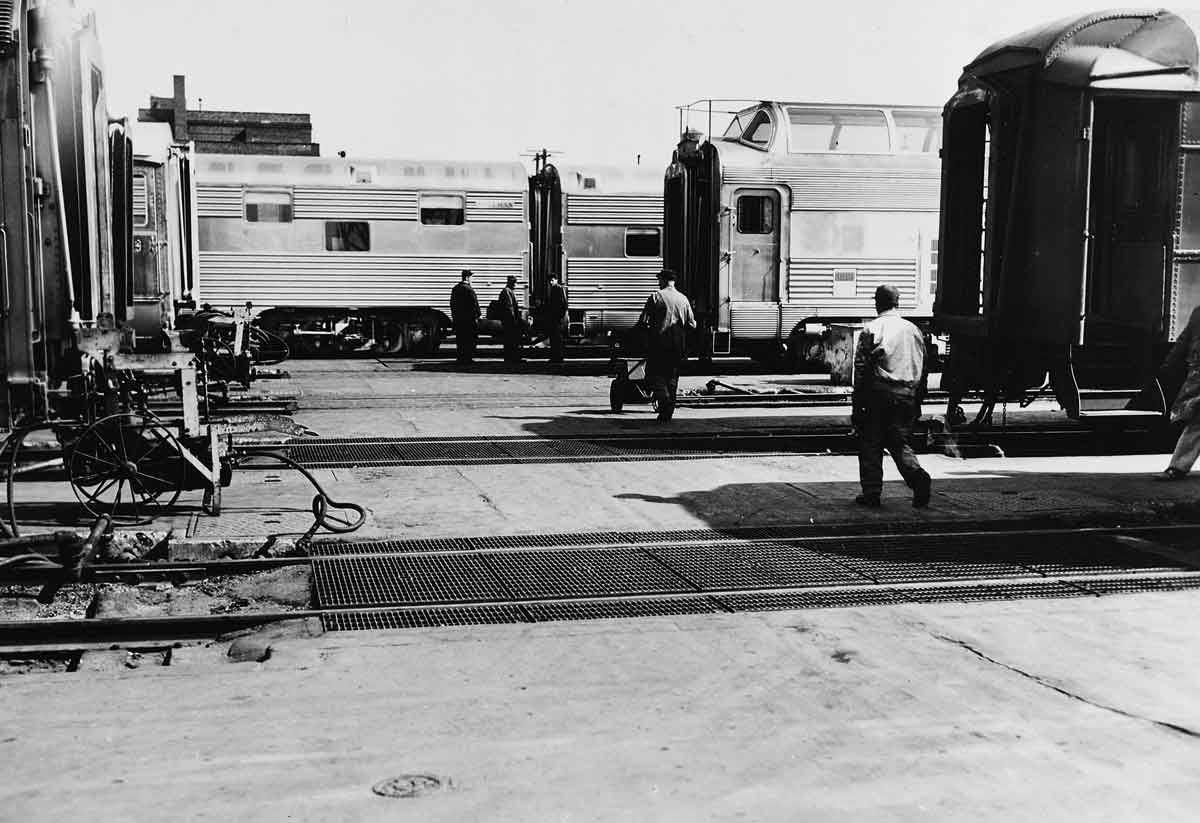 People walking by parked passenger trains