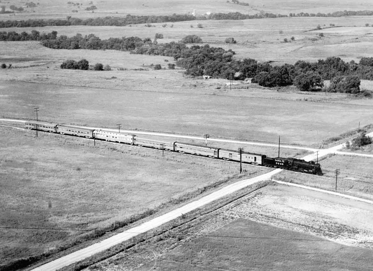 A distant, overhead shot, of a train passing through a rural area