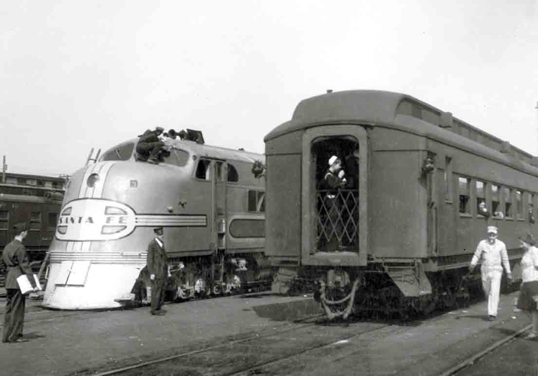 Workers walking around two passenger trains