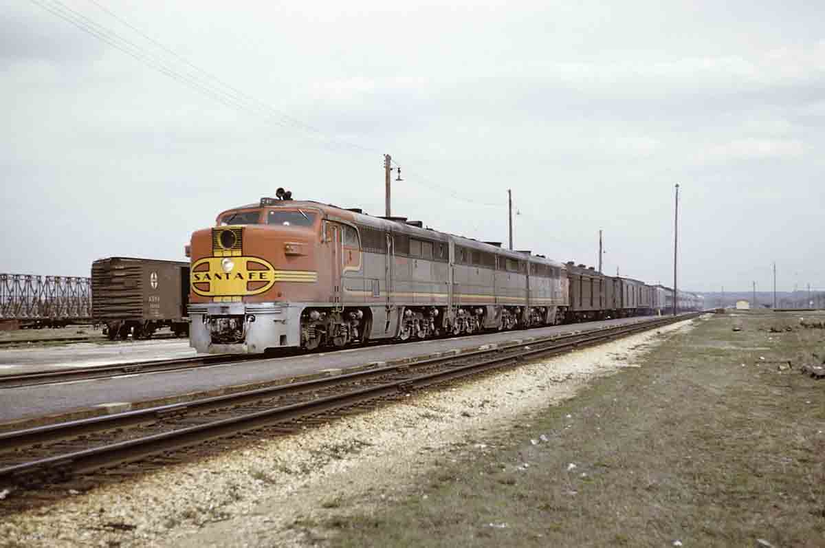 An orange and yellow train sitting on the tracks