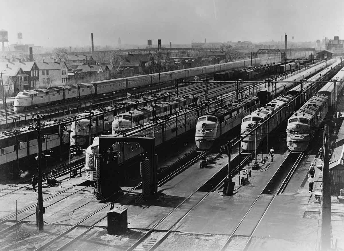 a train yard with 7 passenger trains side by side