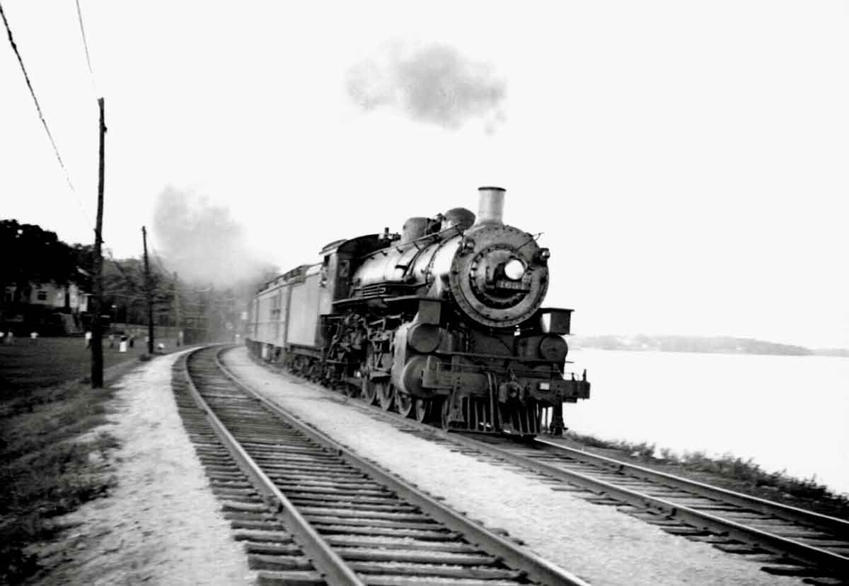a steam engine pulling passenger cars