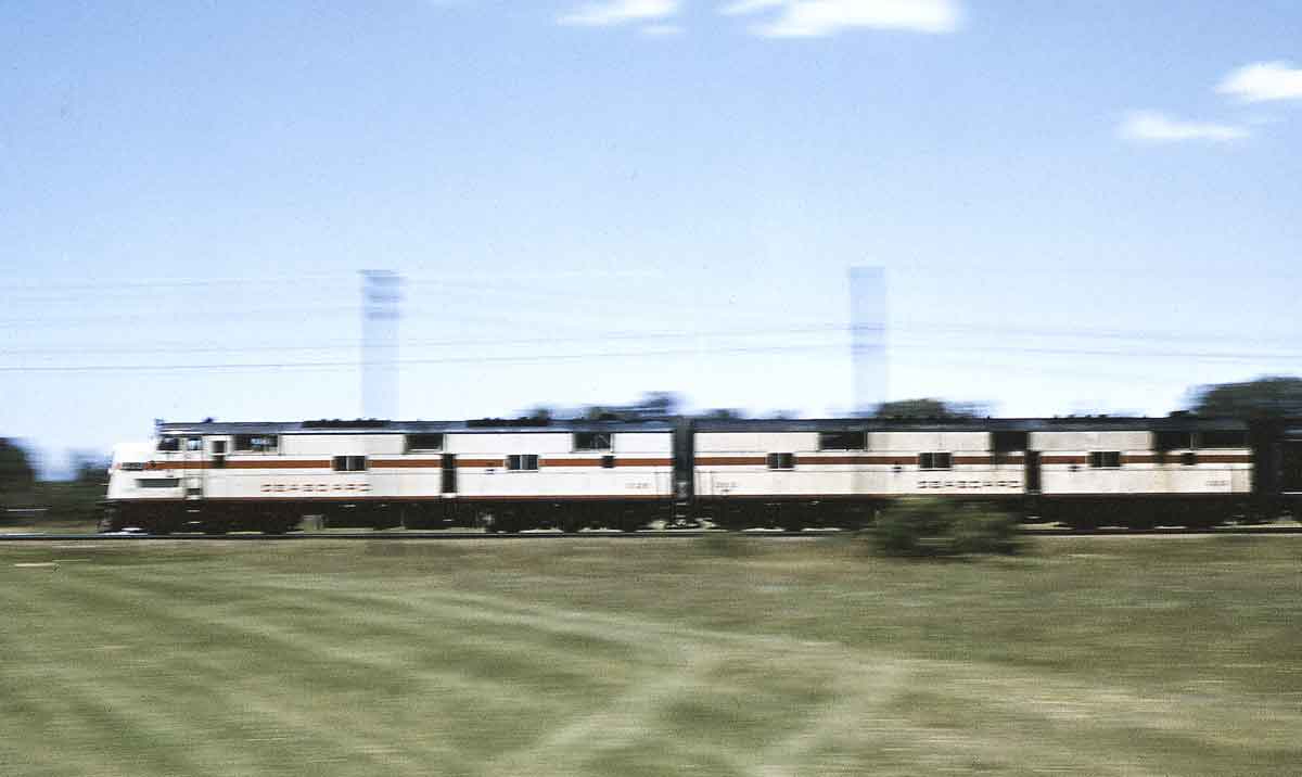 Diesel locomotives haul a passenger train.