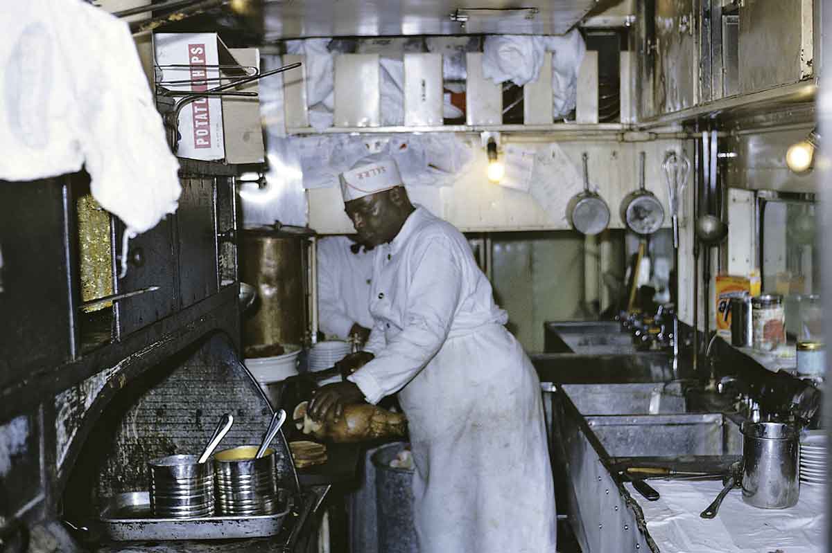 A railway chef in his kitchen. Color photo.