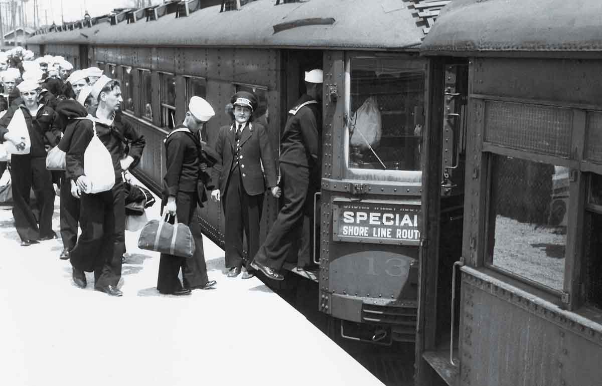 a line of sailors boarding a passenger train