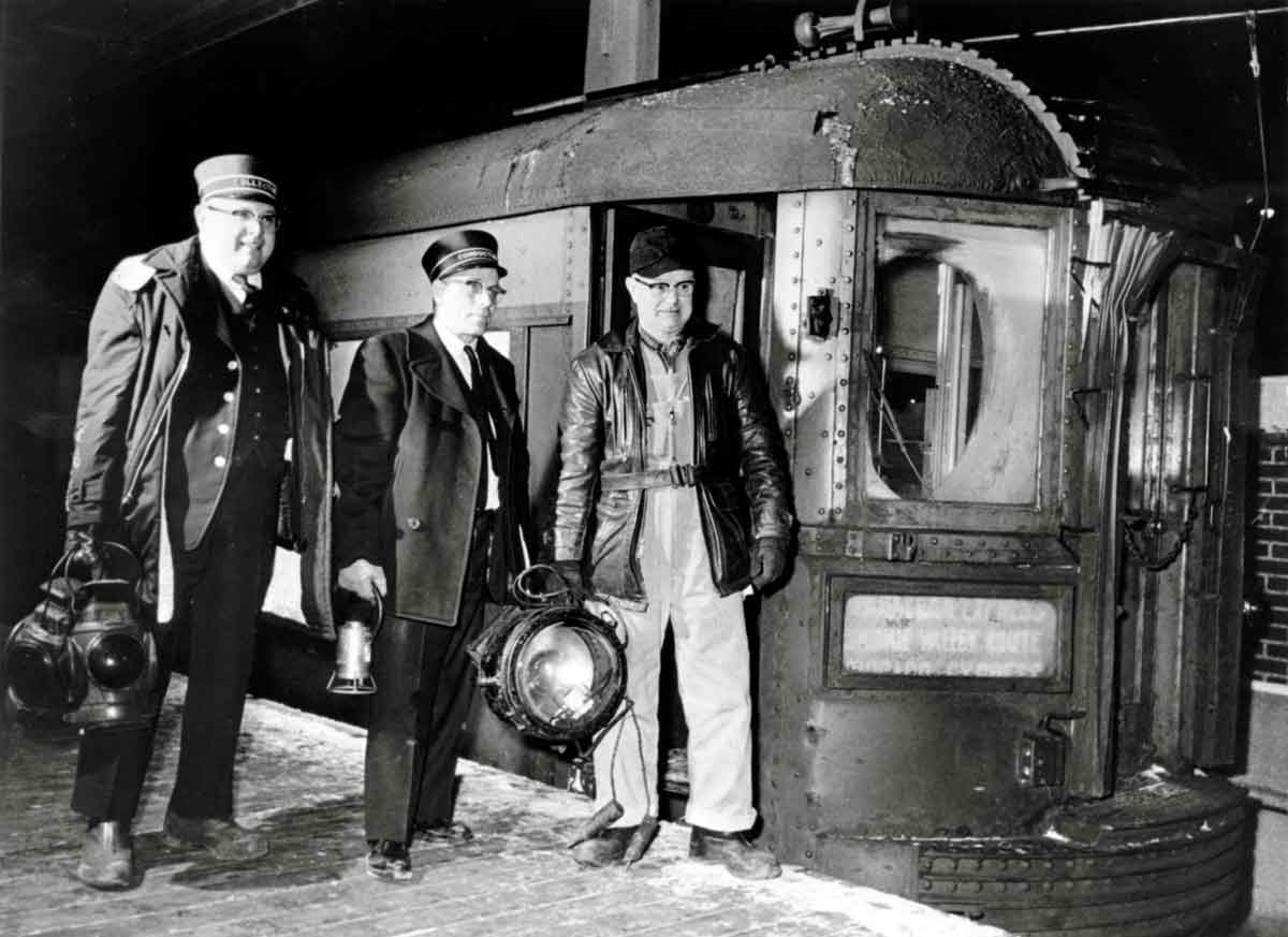 an engineer, conductor, and a third person standing by a passenger train