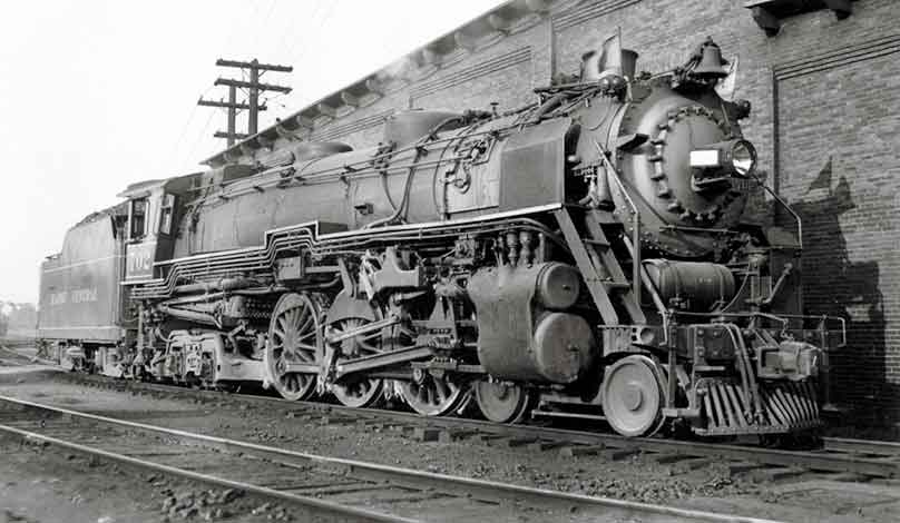 A black and white photo of a train sitting on the tracks