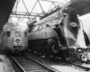 a passenger car next to a streamliner