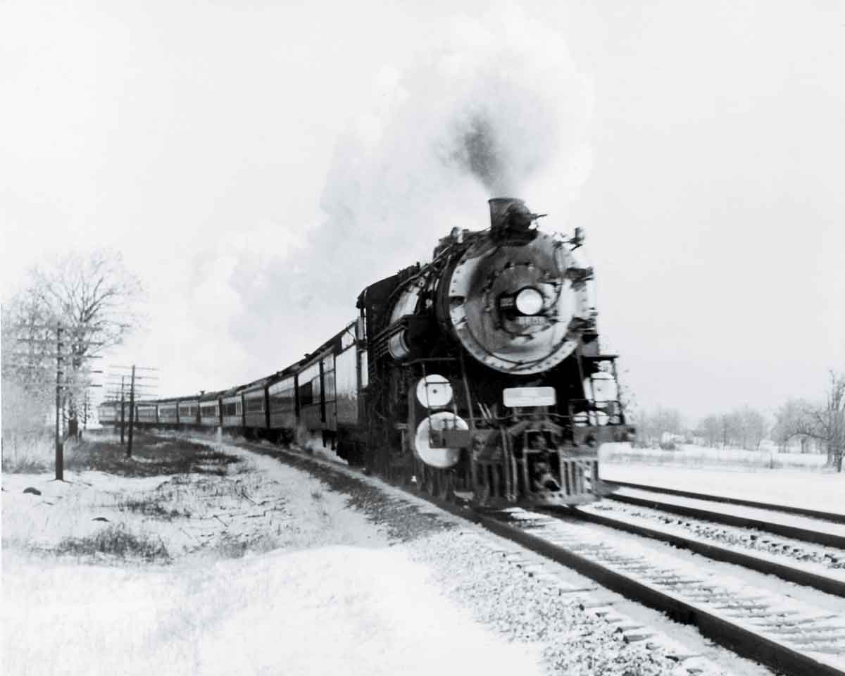 a steam engine pulling passenger cars