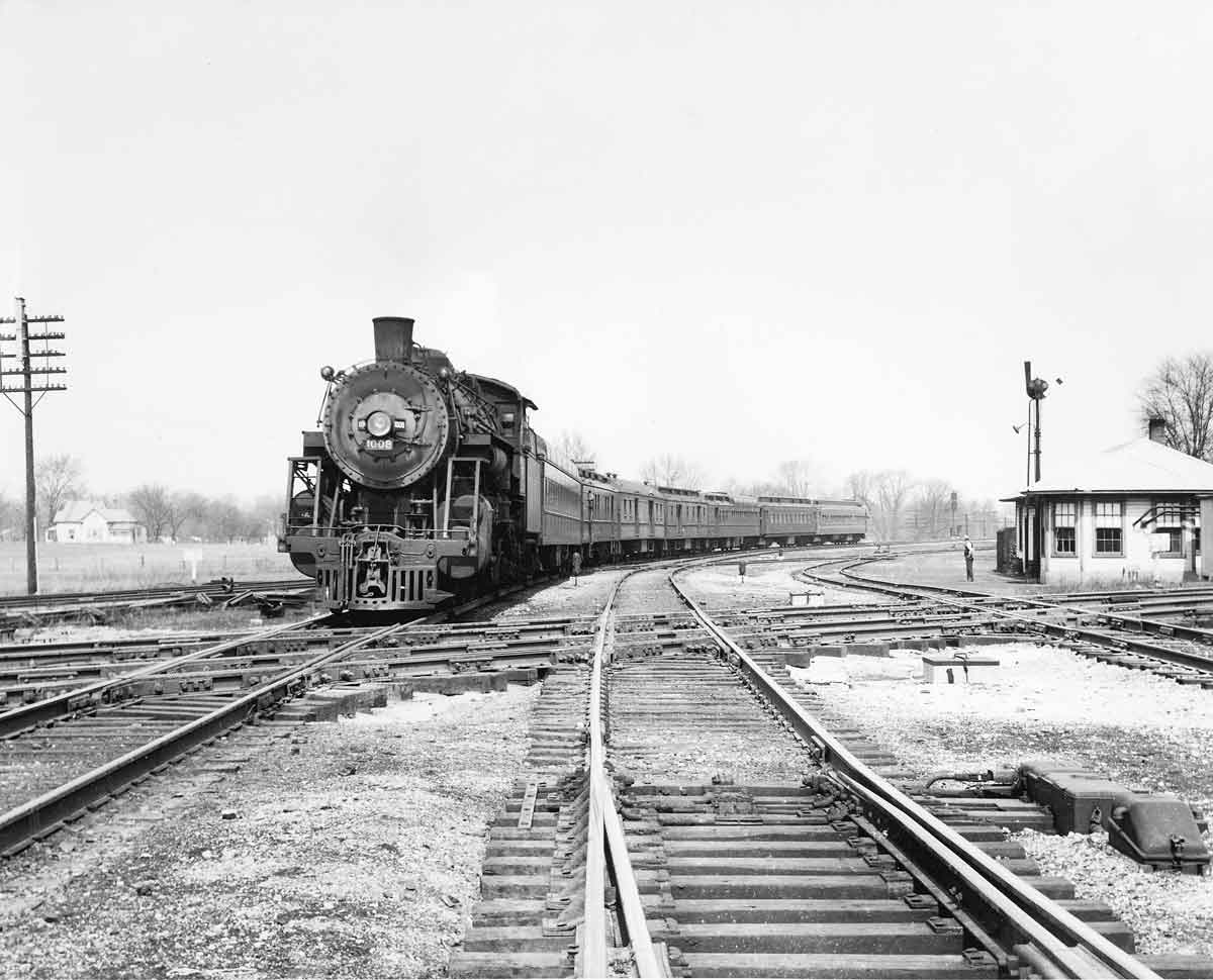 a steam engine pulling passenger cars
