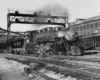 a steam engine pulling passenger cars