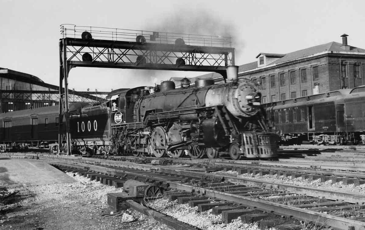 a steam engine pulling passenger cars