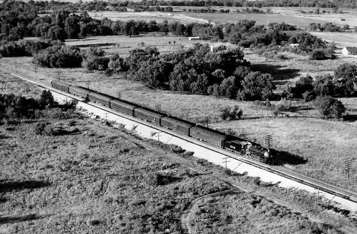 a steam engine pulling passenger cars