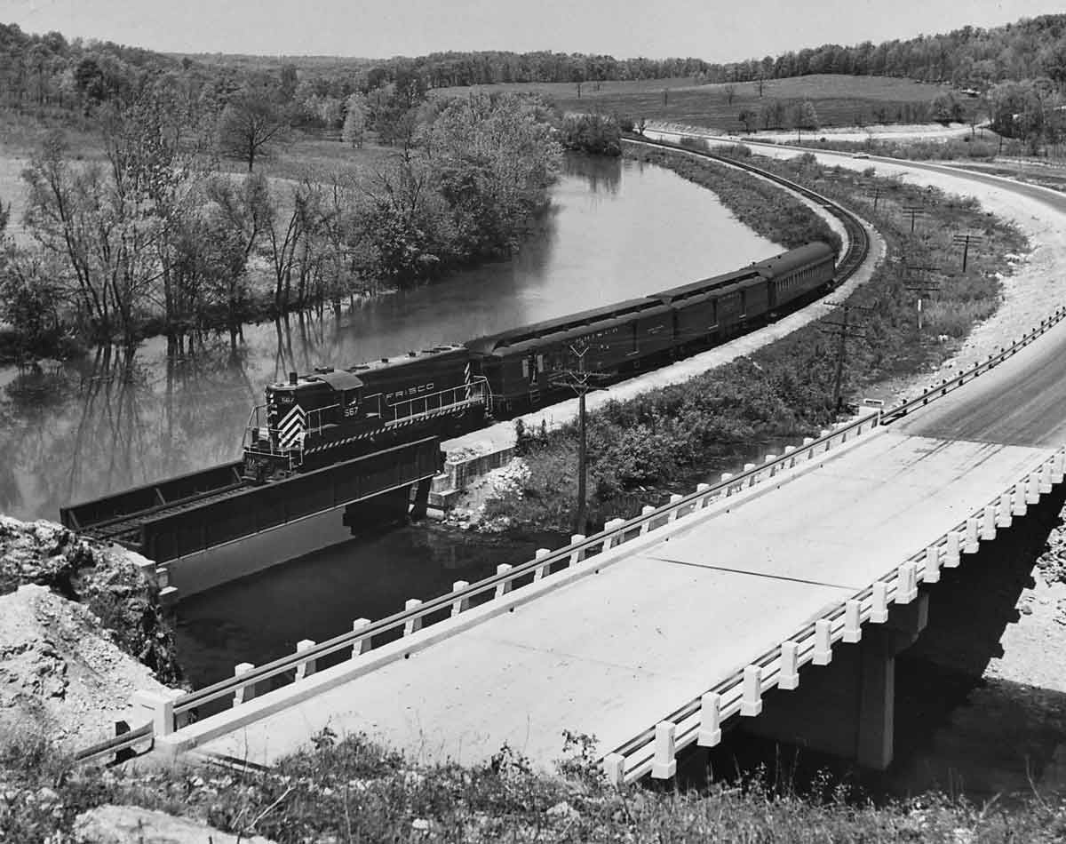 a passenger train crossing a bridge over a river