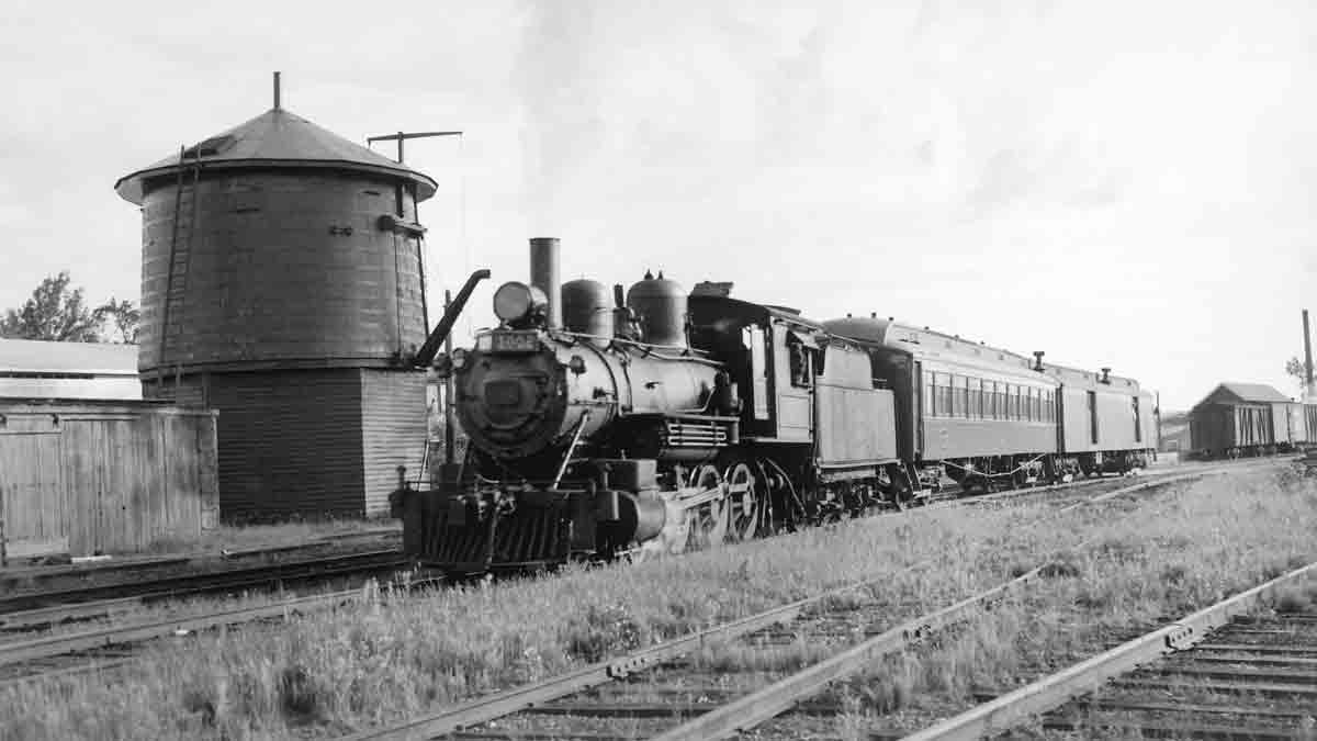 a steam engine pulling passenger cars