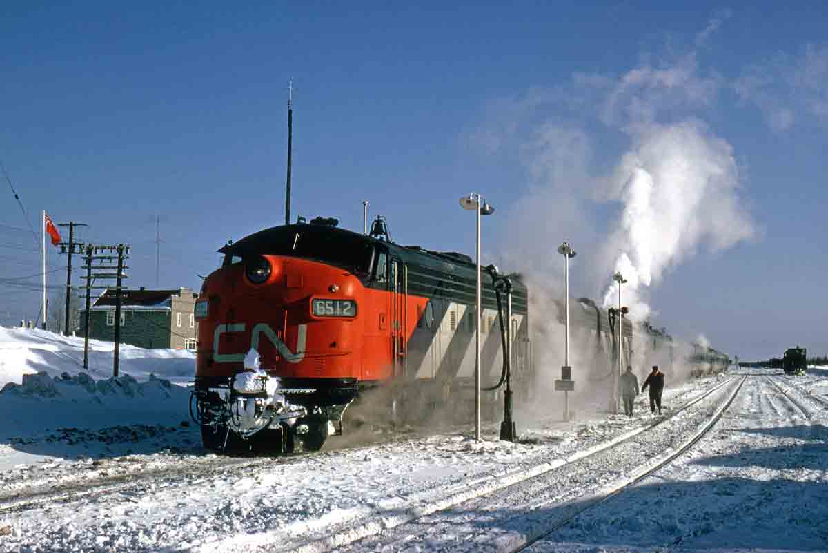 a diesel passenger train by a snowy field