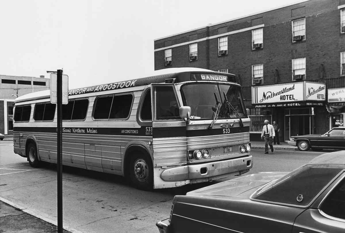 a bus in a street with a hotel in the background