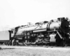 a steam engine with passenger cars