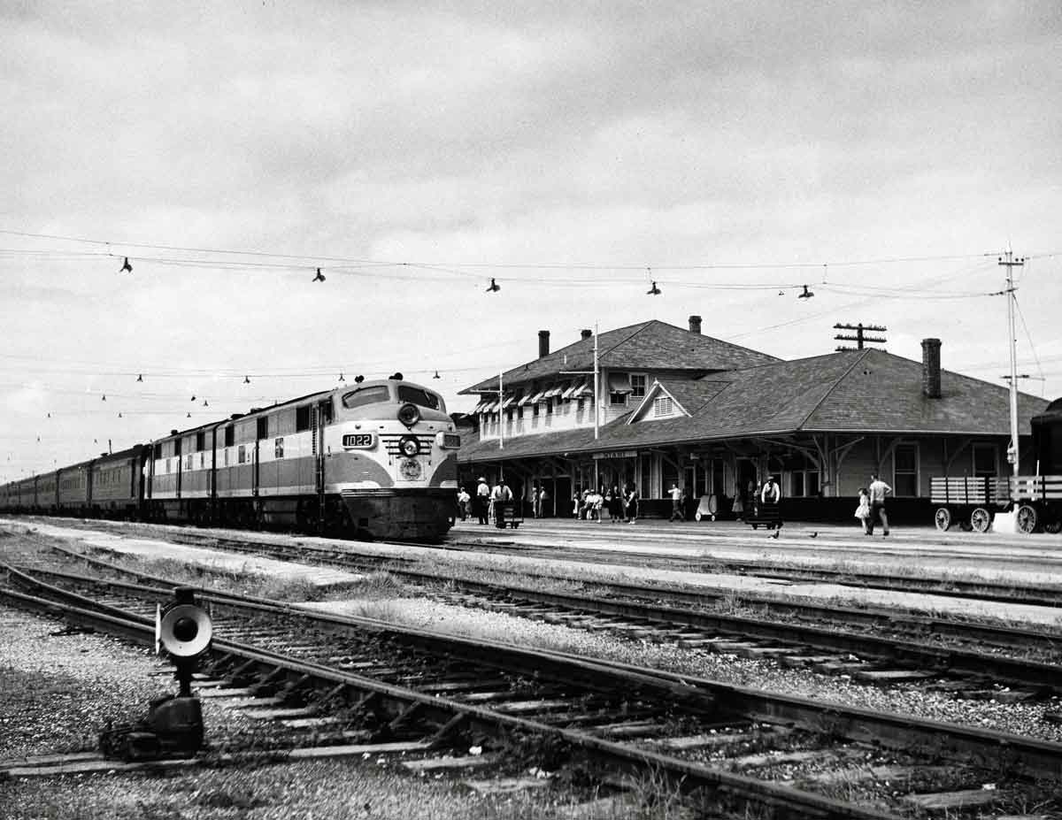 a diesel passenger train by a passengerstation