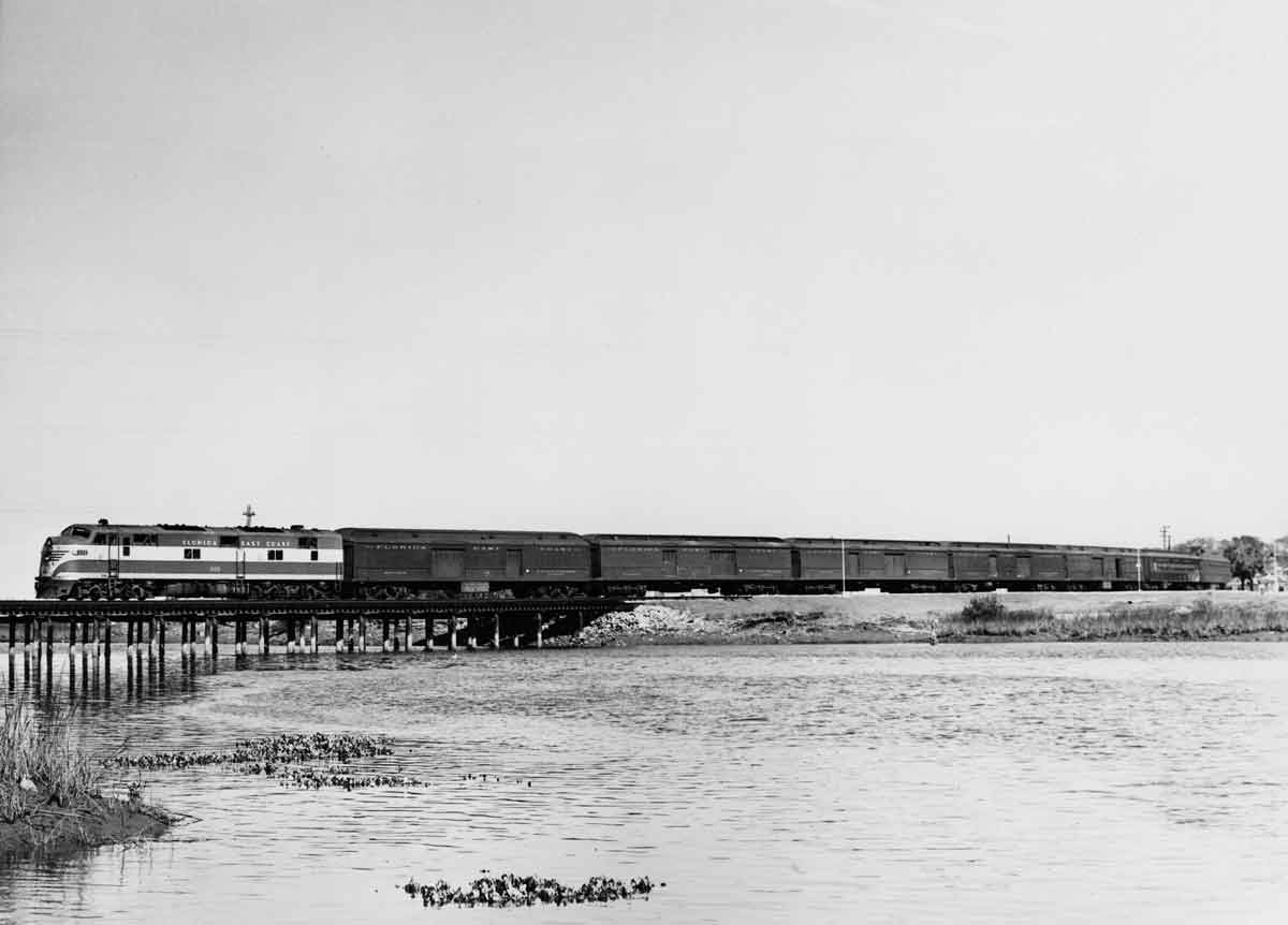 a train on a small bridge over water