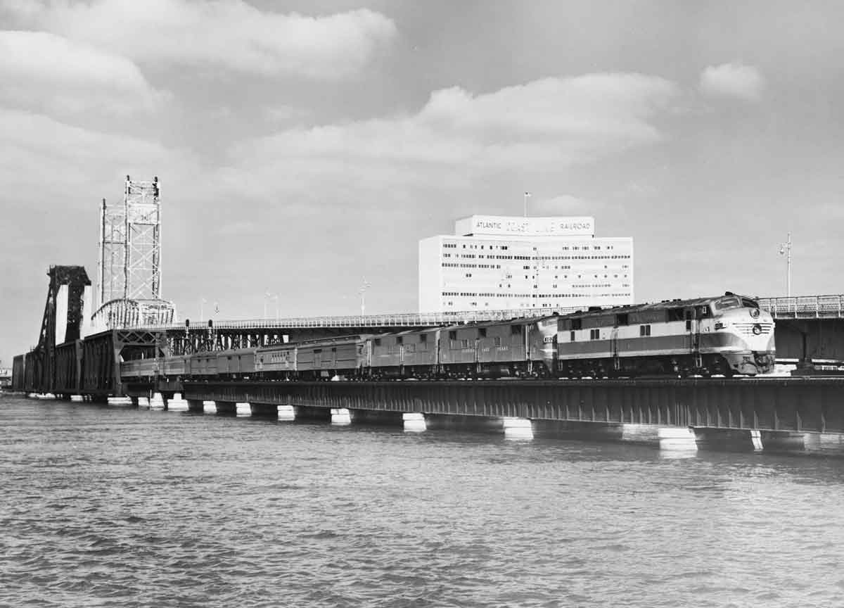 a passenger train on a bridge crossing water