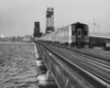 a passenger train crossing a large bridge with Jacksonville in the background