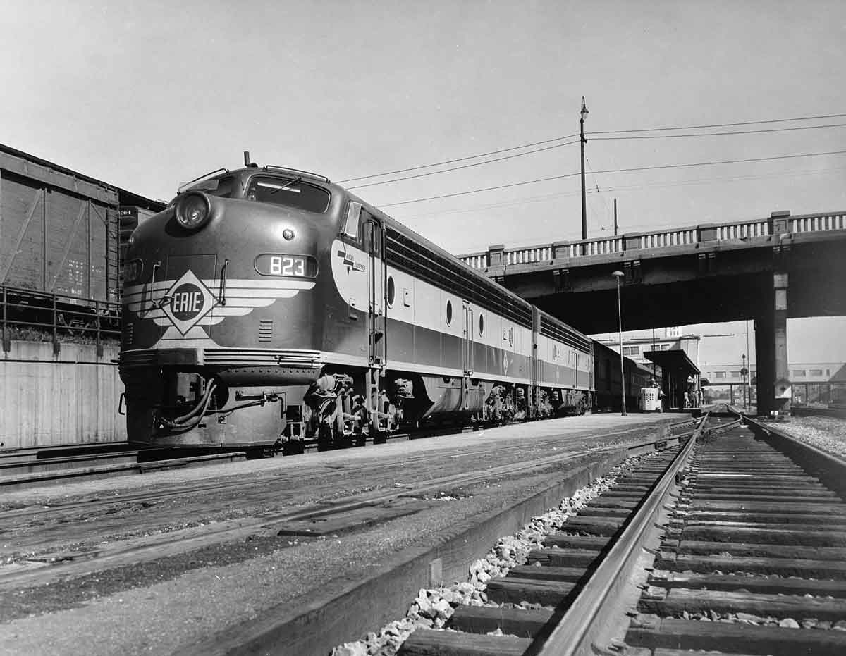 A black and white photo of a train leaving a station