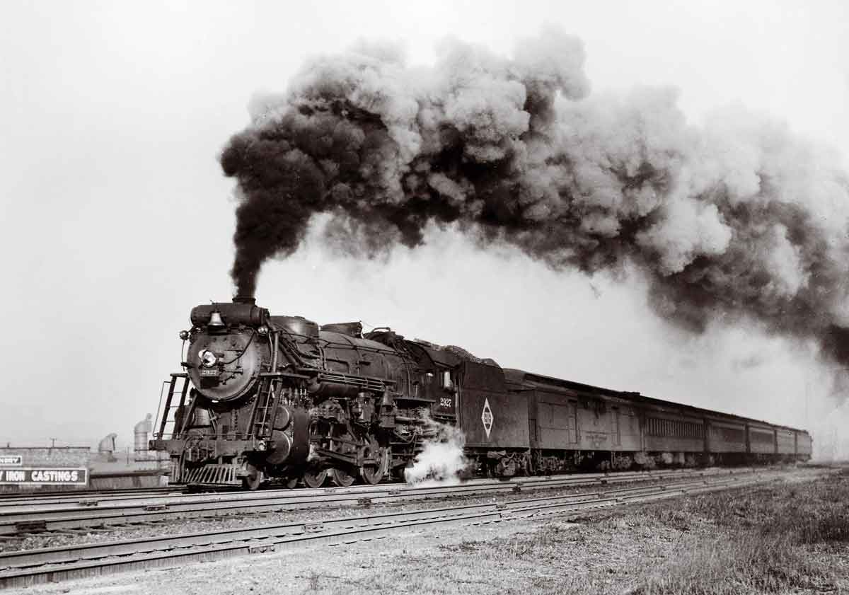 A black and white photo of a train with big black smoke coming out of its chimney