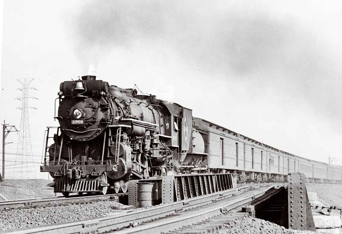 A black and white photo of a train passing by