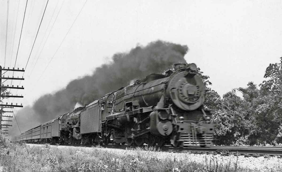 A train speeding by with black smoke coming out of its chimney