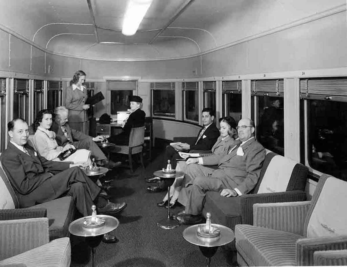 A hostess serving passengers in an observation car