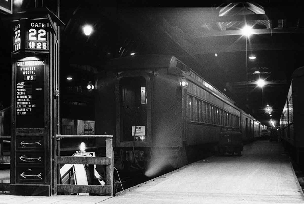 A passenger train sitting at a passenger depot