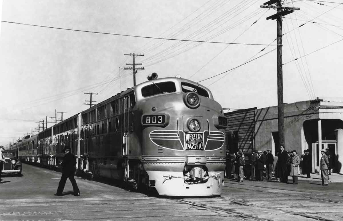 a diesel and passenger cars at a passenger depot