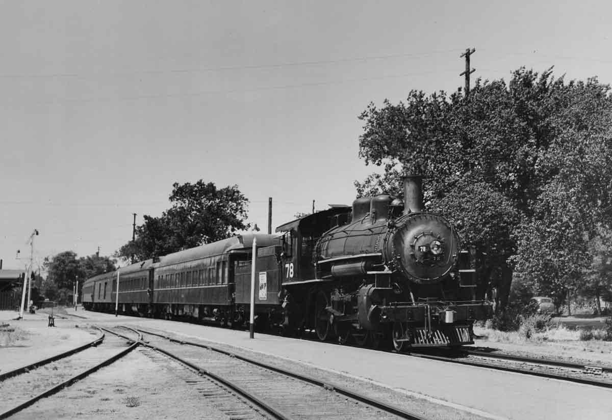 a steam engine pulling passenger cars
