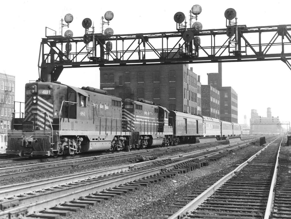 A train passing below a stoplight