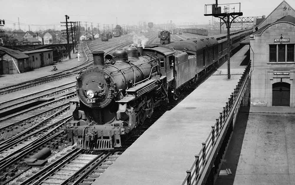 a steam engine pulling passenger cars